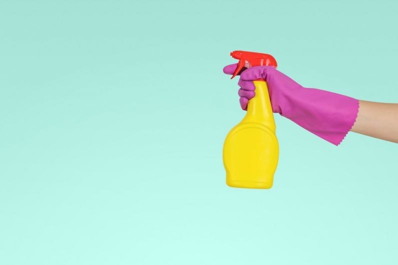 Cleaning - person holding yellow plastic spray bottle