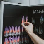Magnetic Refrigerators - a person holding a book in front of a display of magnets