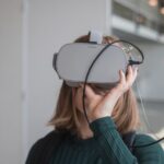 Innovations - woman in black sweater holding white and black vr goggles